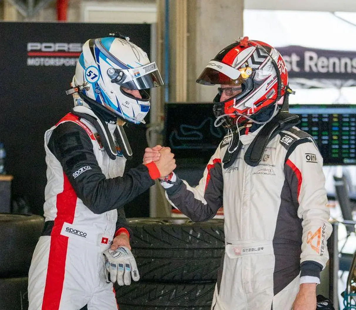 Two drivers shaking hands in the pit lane
