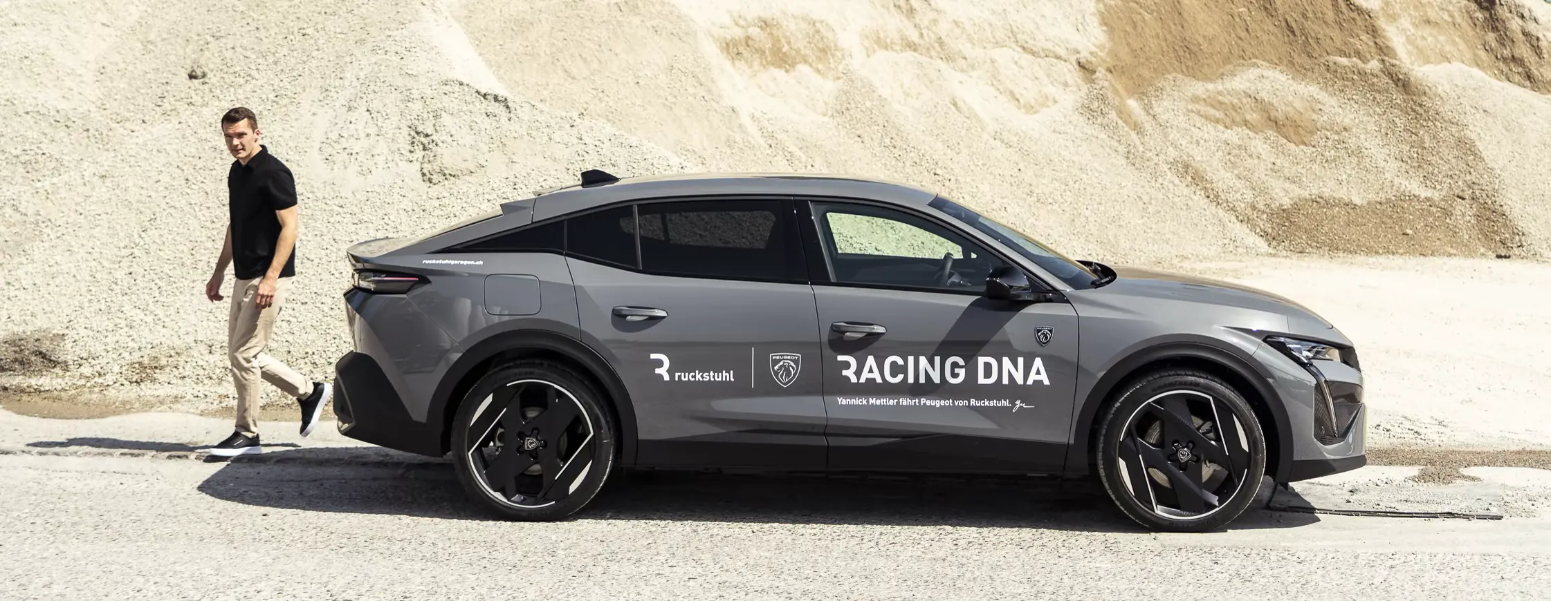 Peugeot in Racing DNA livery on a gravel track, Yannick Mettler walking alongside