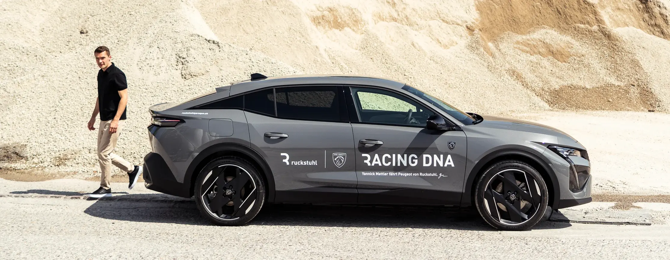 Peugeot in Racing DNA livery on a gravel track, Yannick Mettler walking alongside